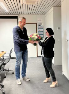 Karsten Müller übergibt Blumen an Katrin Letzgus-Danhach Vertiebseitung IMPREG GmbH